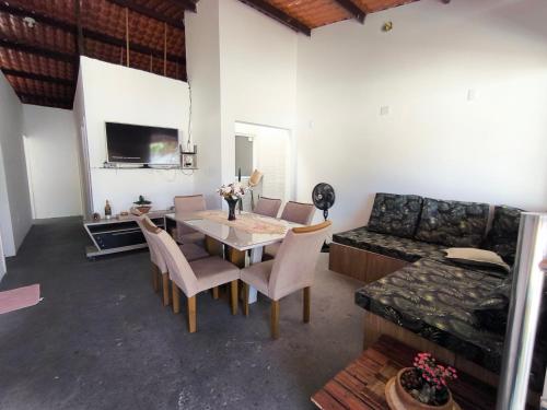 a living room with a table and chairs and a couch at Casa de Praia Em Aracaju,Se in Barra dos Coqueiros