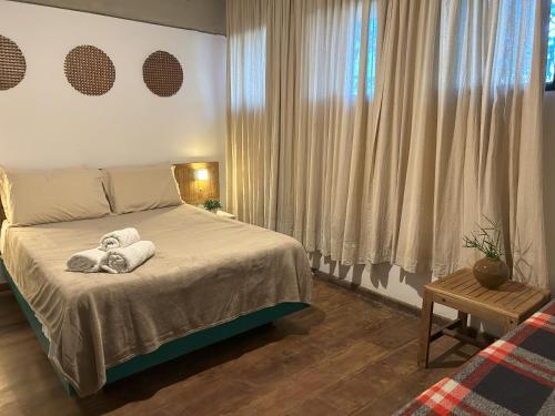 a bedroom with a bed with towels on it at Pitaya Suítes in Cunha