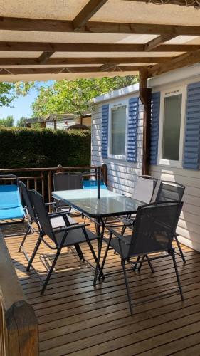 un patio avec une table et des chaises sur une terrasse dans l'établissement Location de Mobil-home 6 à 8 personnes , Vias Camping la Carabasse, à Vias