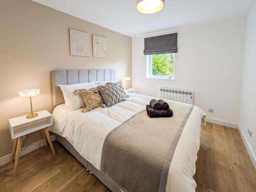 a bedroom with a bed with a teddy bear on it at Highland Cow Apartment in Inverness