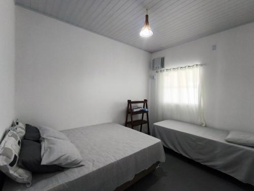 a bedroom with two beds and a window at Casa de Praia Em Aracaju,Se in Barra dos Coqueiros