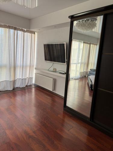 a living room with a mirror and a hard wood floor at Отдых у моря Одесса in Kryzhanivka