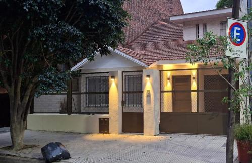 a house with a garage with a sign in front of it at Dos habitaciónes independientes con baño privado en casa familiar in Vicente López