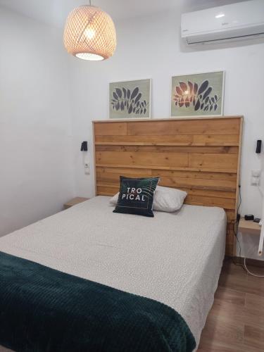 a bedroom with a large bed with a wooden headboard at Del Carmen in Vinarós