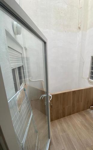 a glass shower door with a bench in a room at Del Carmen in Vinarós