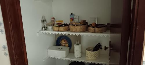 a shelf with baskets and other items on it at Casa José & Maria, casa espaçosa para famílias e grupos até 10 pessoas in Braga