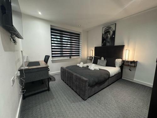 a bedroom with a bed and a desk and a laptop at Luxury 2 Bed West London, Free Parking in Uxbridge