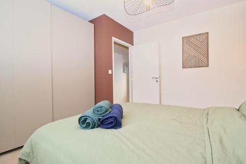 a bed with blue towels sitting on top of it at VILLA PERIGORD 1- Spacieux - clim - wifi - parking - Jardin in Le Pontet