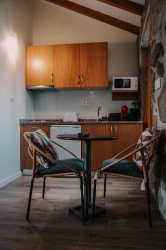 a kitchen with two chairs and a table and a counter at Casa da Mina - Pendilhe in Pendilhe