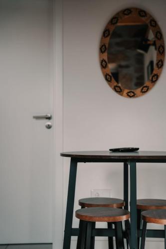 a mirror on the wall above a table with stools at Casa da Mina - Pendilhe in Pendilhe