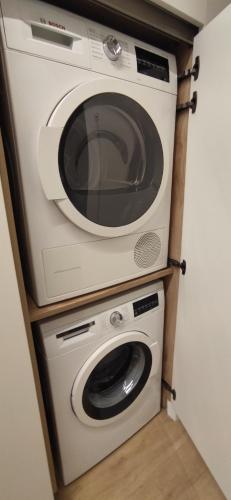 a microwave and a washer and dryer in a room at Kaioen Etxea EBI 03150 in Getxo