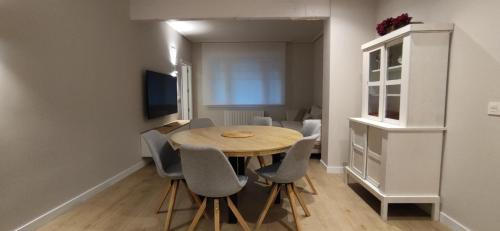 a dining room with a wooden table and chairs at Kaioen Etxea EBI 03150 in Getxo