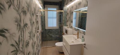 a bathroom with a sink and a toilet and a window at Kaioen Etxea EBI 03150 in Getxo