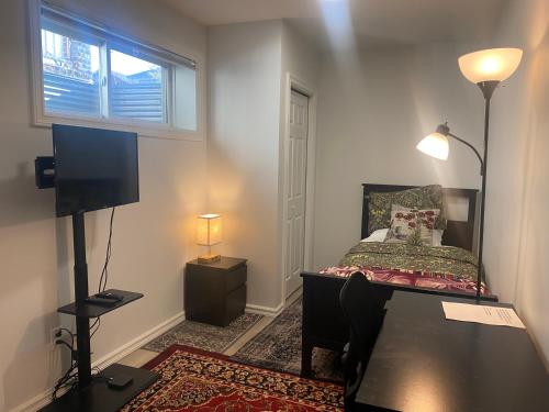 a small bedroom with a bed and a television at Blue Kuti B&B in Edmonton