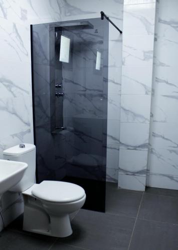 a white bathroom with a toilet and a shower at Urban Confort in Nouakchott