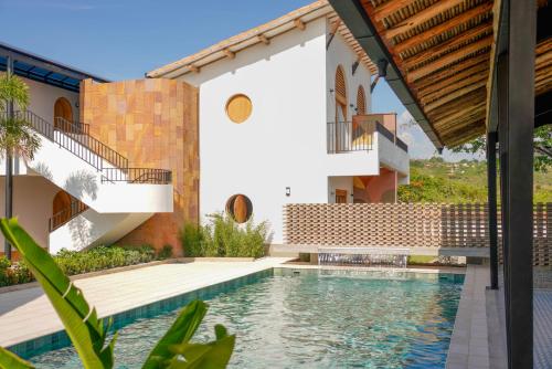 a house with a swimming pool next to a building at Hotel campanario campestre barichara in Barichara