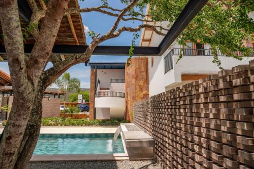 a house with a swimming pool and a brick wall at Hotel campanario campestre barichara in Barichara