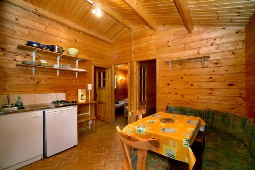 a kitchen and dining room with a table in a cabin at Camping U STABIACCIU in Porto-Vecchio