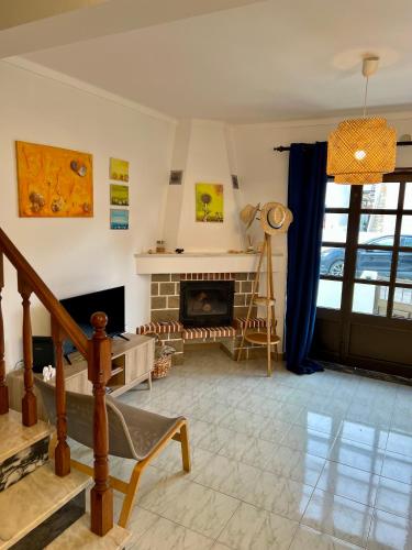 a living room with a fireplace and a staircase at Seashell Consolação in Atouguia da Baleia