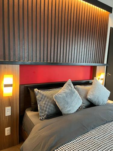 a bedroom with a bed with a red headboard and pillows at 1 Bedroom with Balcony in Abreeza Mall in Davao City