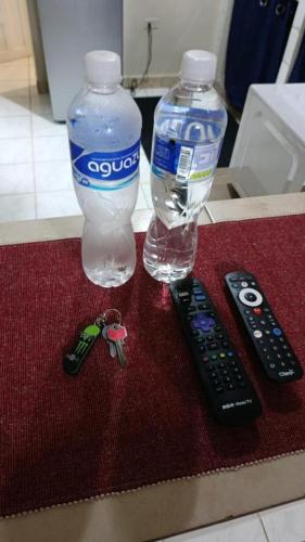 two bottles of water and two remote controls on a counter at 10 minutos de Plaza Miraflores Casa Completa de 2 habitaciones con garaje in Tegucigalpa