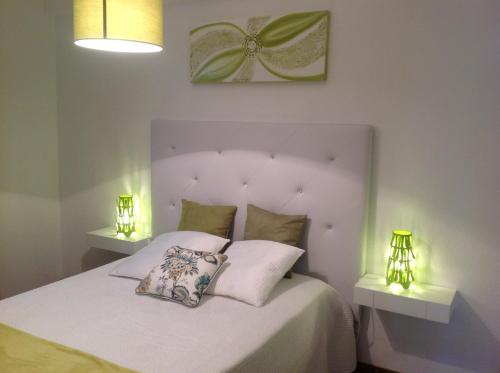 ein Schlafzimmer mit einem weißen Bett mit zwei Lampen in der Unterkunft Casa do Mar in Sesimbra