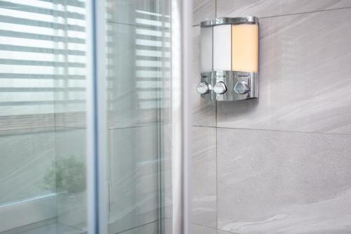 a bathroom with a soap dispenser on the wall at Prime House - St James Park - Newcastle in Newcastle upon Tyne