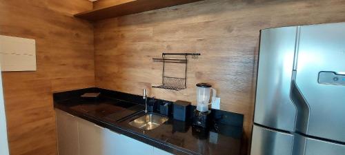 a kitchen with a sink and a refrigerator at Parque do Cais - Flats Premium no Recife por Yolo in Recife