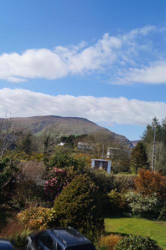 a mountain in the distance with a car in the foreground at Ardrinane House in Annascaul