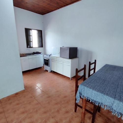 a room with a table and a kitchen with a microwave at Apartamento com Ar Condicionado in Nova Andradina
