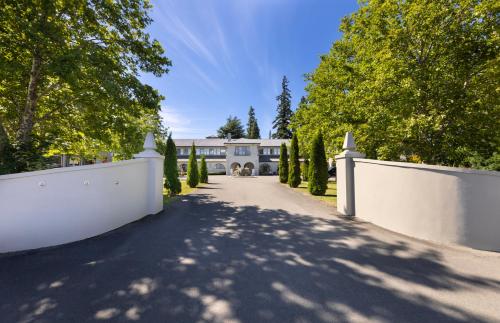 a driveway leading to a house with a white fence at Edit Hanmer Springs in Hanmer Springs