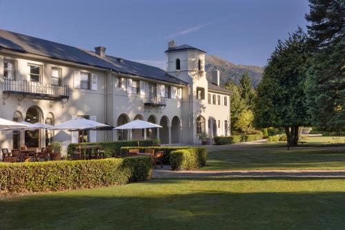 a large white building with tables and umbrellas at Edit Hanmer Springs in Hanmer Springs