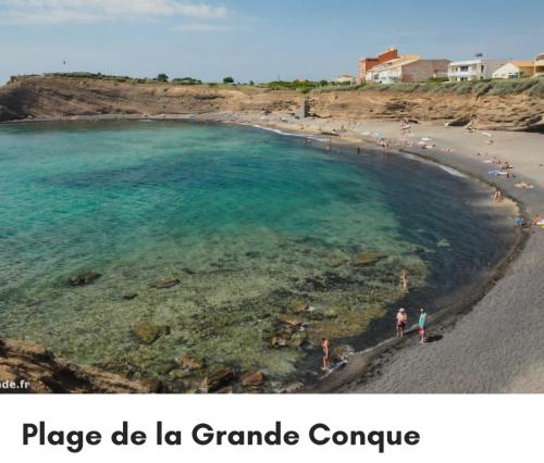 une vue d'une plage avec des gens dans l'eau dans l'établissement Pecheurs, à Agde