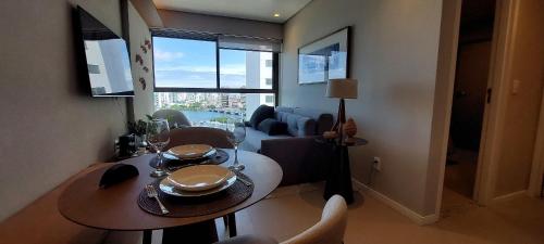 a living room with a dining table and a couch at Parque do Cais - Flats Premium no Recife por Yolo in Recife