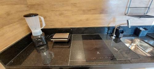 a counter top with a blender and a sink at Parque do Cais - Flats Premium no Recife por Yolo in Recife