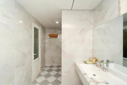 a white bathroom with a tub and a sink at Hoa Lư Hotel in Sầm Sơn