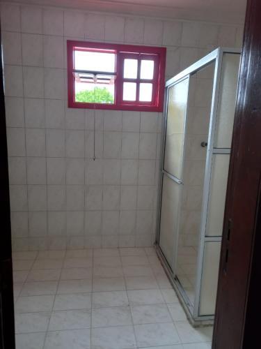 a bathroom with a window and a refrigerator at Hotel raizes in Conceição do Coité