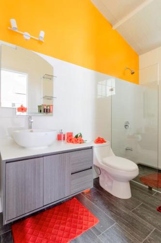 a bathroom with a sink and a toilet and a mirror at La Magia Bungalows in Puerto Viejo