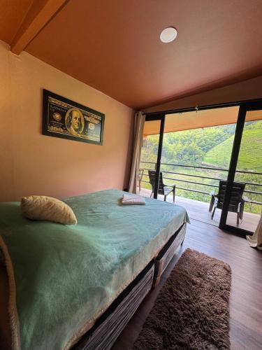 a bedroom with a bed and a large window at Tesoro Quimbaya IG quimbayacabana in La Florida