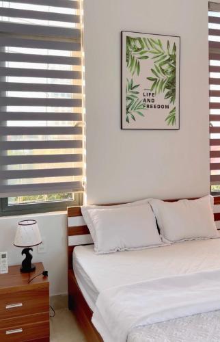 a bedroom with a bed with white sheets and a window at 150 Homestay in Dong Hoi
