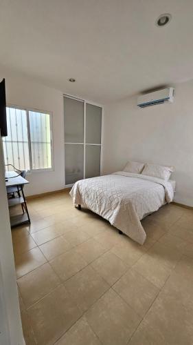 a bedroom with a bed and a desk in it at Casa Yaxche 1 in Izamal