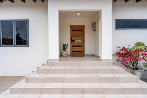 a staircase leading up to a house with flowers at New Villa Jaburibari in Paradera