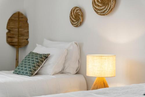a white bed with a pillow and a lamp at New Villa Jaburibari in Paradera
