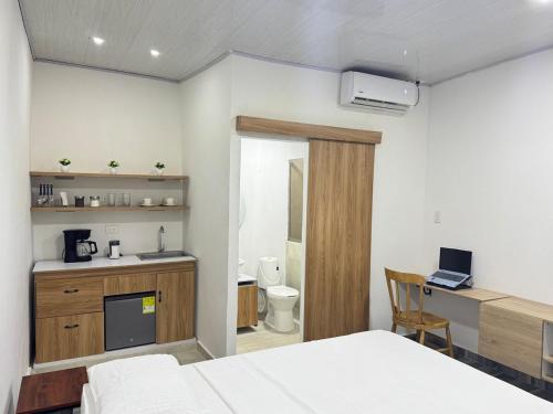 une chambre avec un lit et un bureau et une salle de bain dans l'établissement Studio apartamento en Santa Cruz de Mompox, à Santa Cruz de Mompox