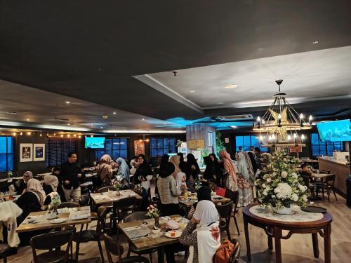 a group of people sitting at tables in a restaurant at Alamis City Kuala Lumpur - Formerly EDC Hotel Kuala Lumpur in Kuala Lumpur