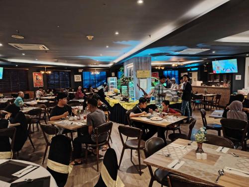 a group of people sitting at tables in a restaurant at Alamis City Kuala Lumpur - Formerly EDC Hotel Kuala Lumpur in Kuala Lumpur