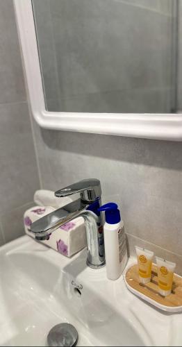 a bathroom sink with a faucet and two cups on it at Quite Studio in Abha