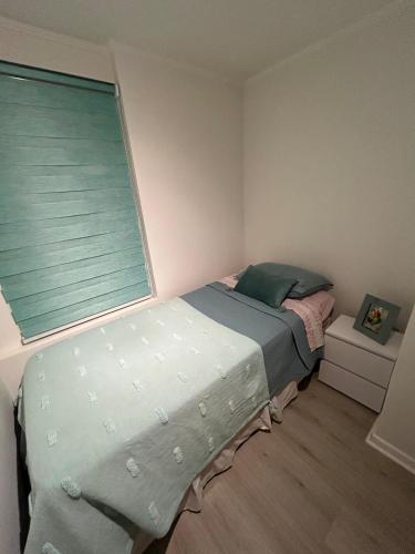 a small bedroom with a bed and a window at Departamento en Quintero in Quintero