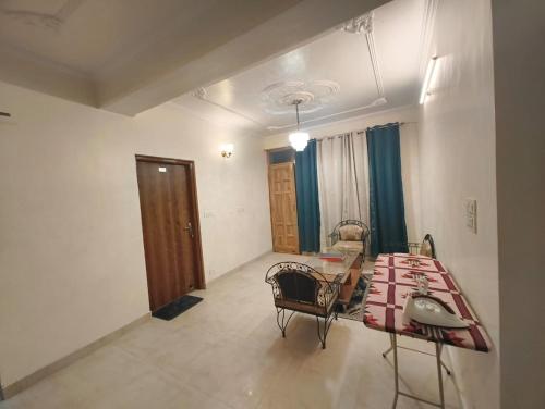 a room with a bed and a table and chairs at Fair lawns Home Stay in Shimla