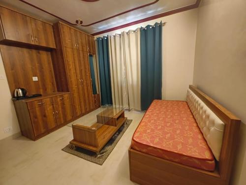 a bedroom with a bed and a dresser in it at Fair lawns Home Stay in Shimla
